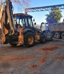 Backhoe loaders parked in a yard awaiting repairs